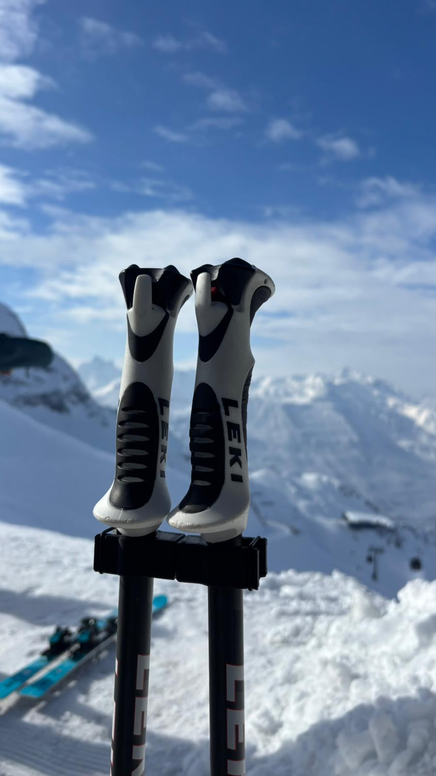 Skistockpaar mit PoleSnap Clips magnetisch verbunden vor verschneiter Berglandschaft